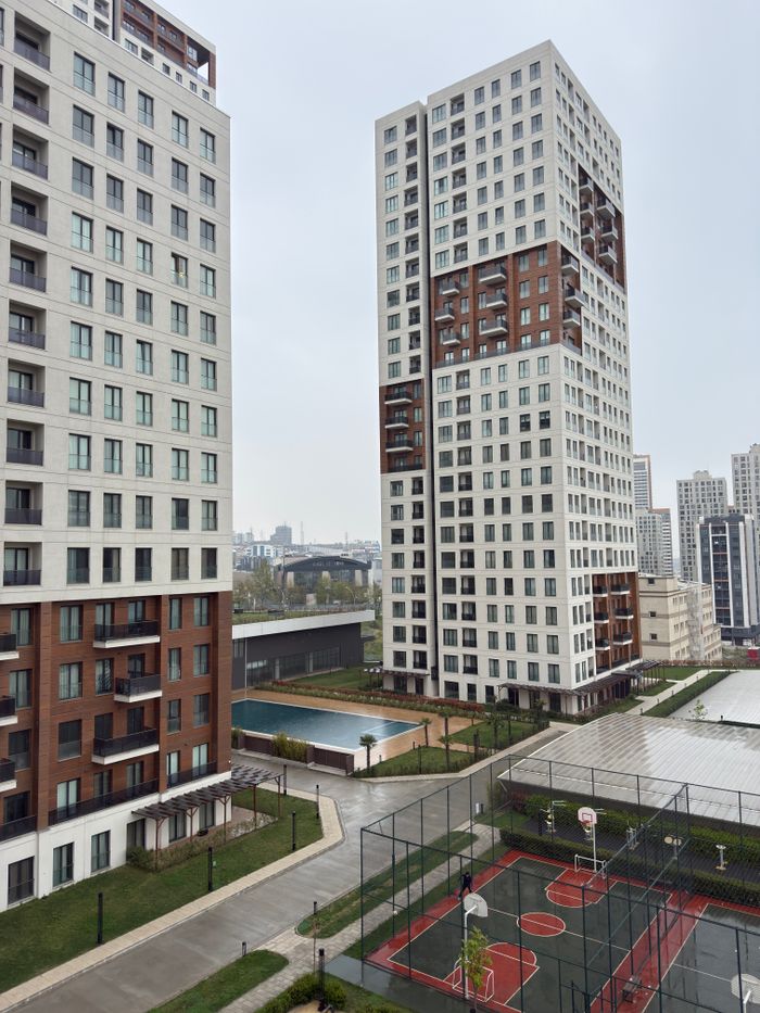 services-03 Modern high-rise buildings with basketball courts and pool in urban residential area.